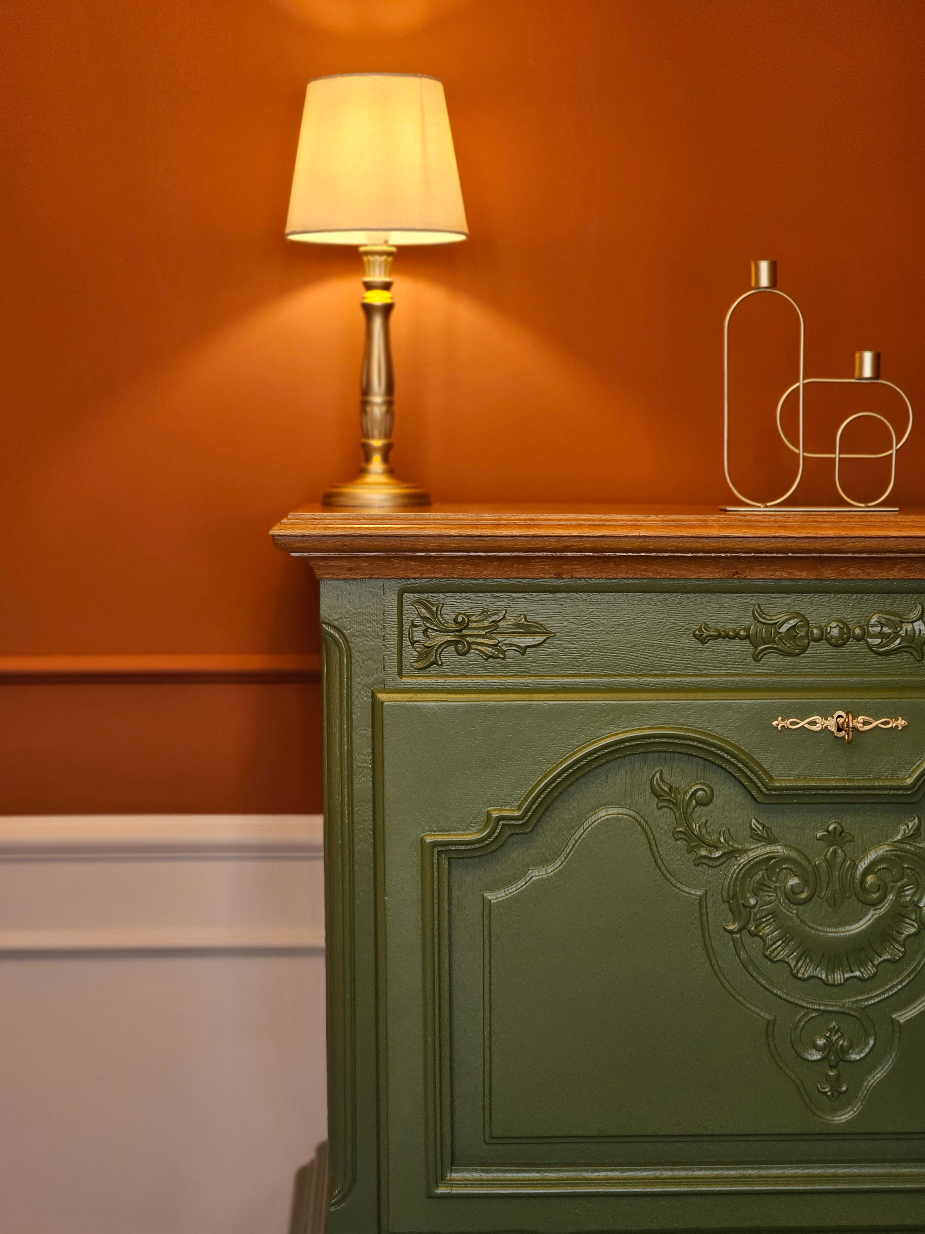 Bar elegant verde cu blat din lemn, integrat într-un decor clasic cu pereți în două tonuri alb și teracotă.
