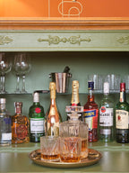 Bar vintage recondiționat, cu tavă aurie, sticle de șampanie și pahare de cristal, într-un decor clasic.