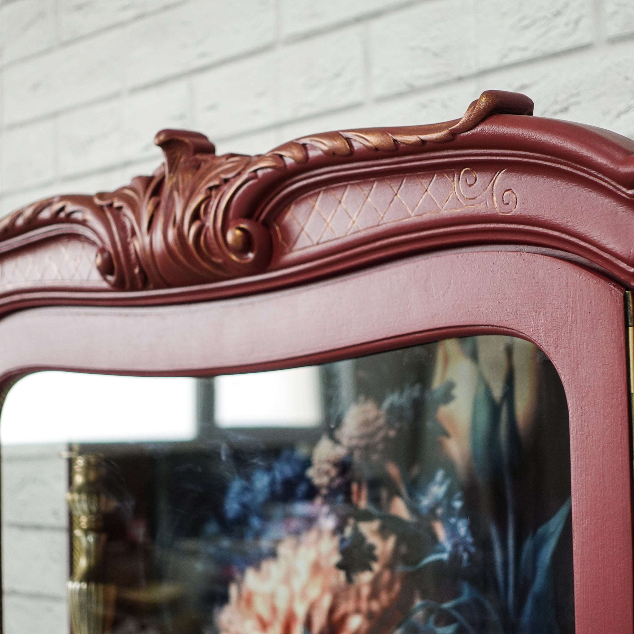 Vitrină vintage burgundy cu detaliu auriu și fundal floral, mobilier recondiționat elegant.